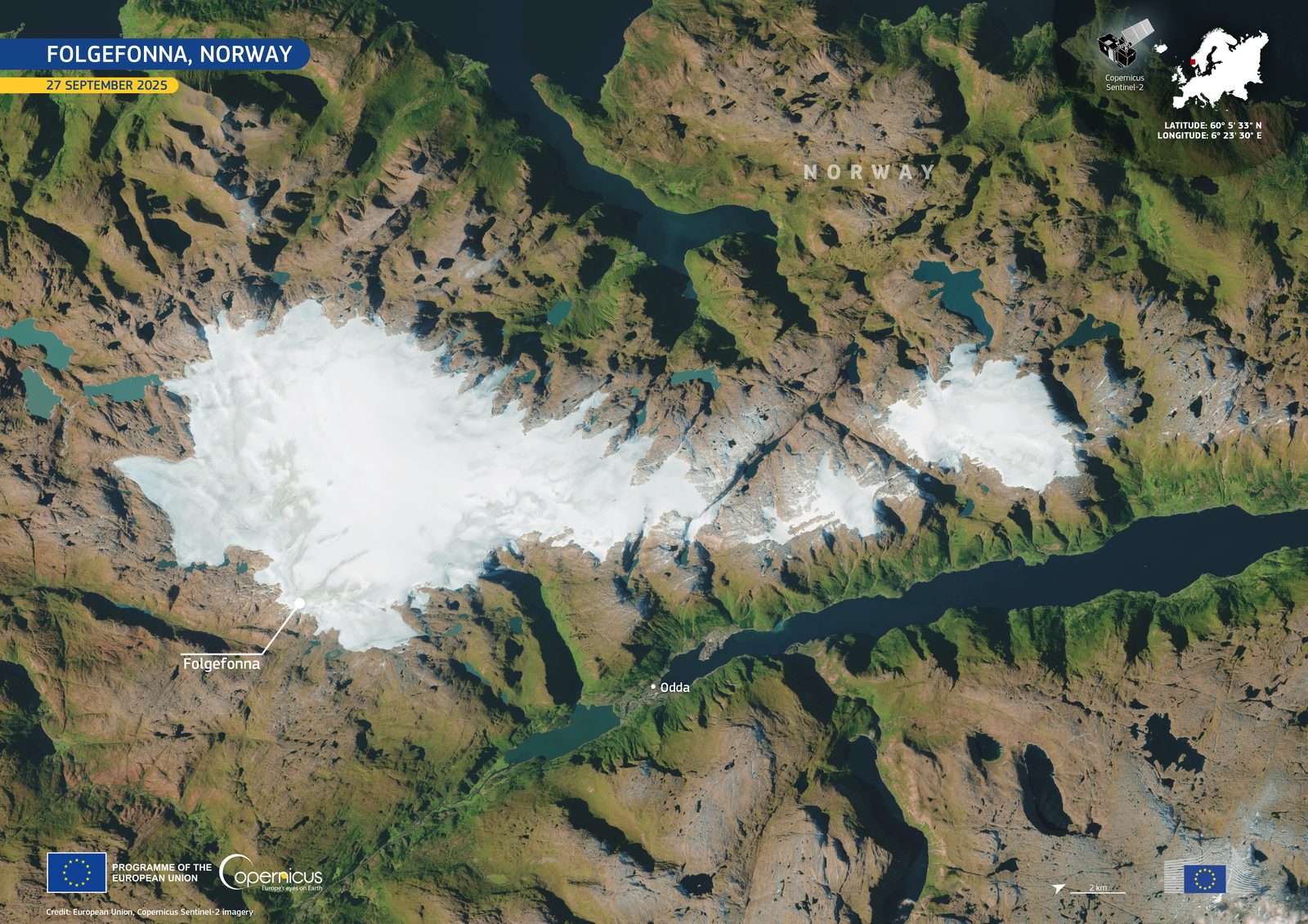 Brevandring med isøks og stegjern på blå is på Folgefonna med Hardangerfjorden i bakgrunnen