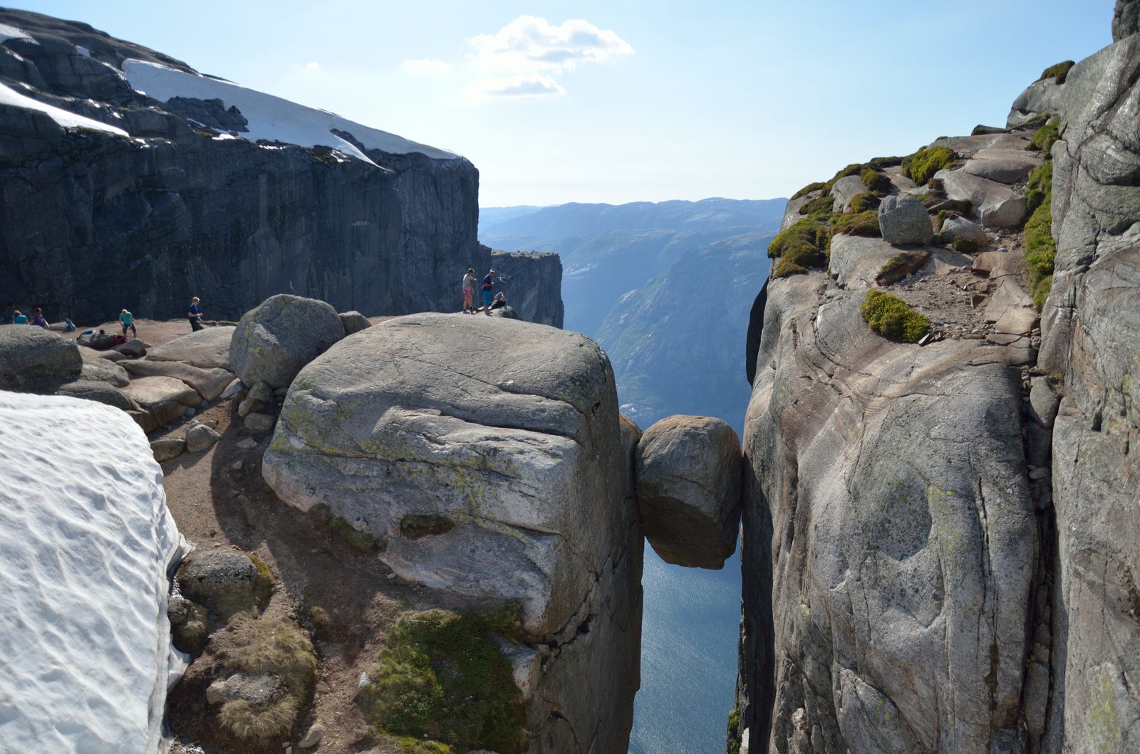 Kjeragbolten klemt mellom to fjellvegger med Lysefjorden langt nede
