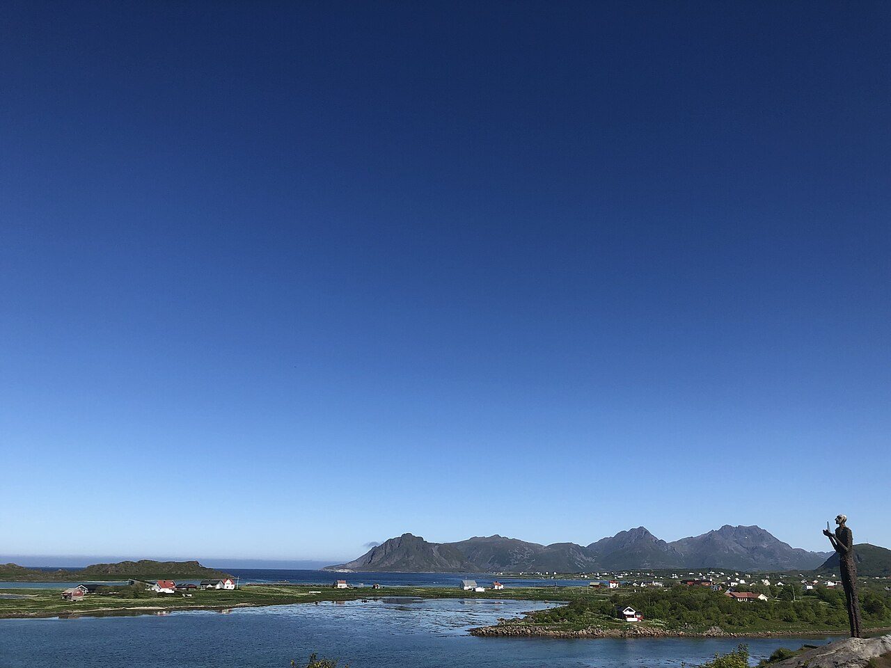 Hvit sandstrand med grønt grasdekke ved Åsandfjorden i Bø i Vesterålen