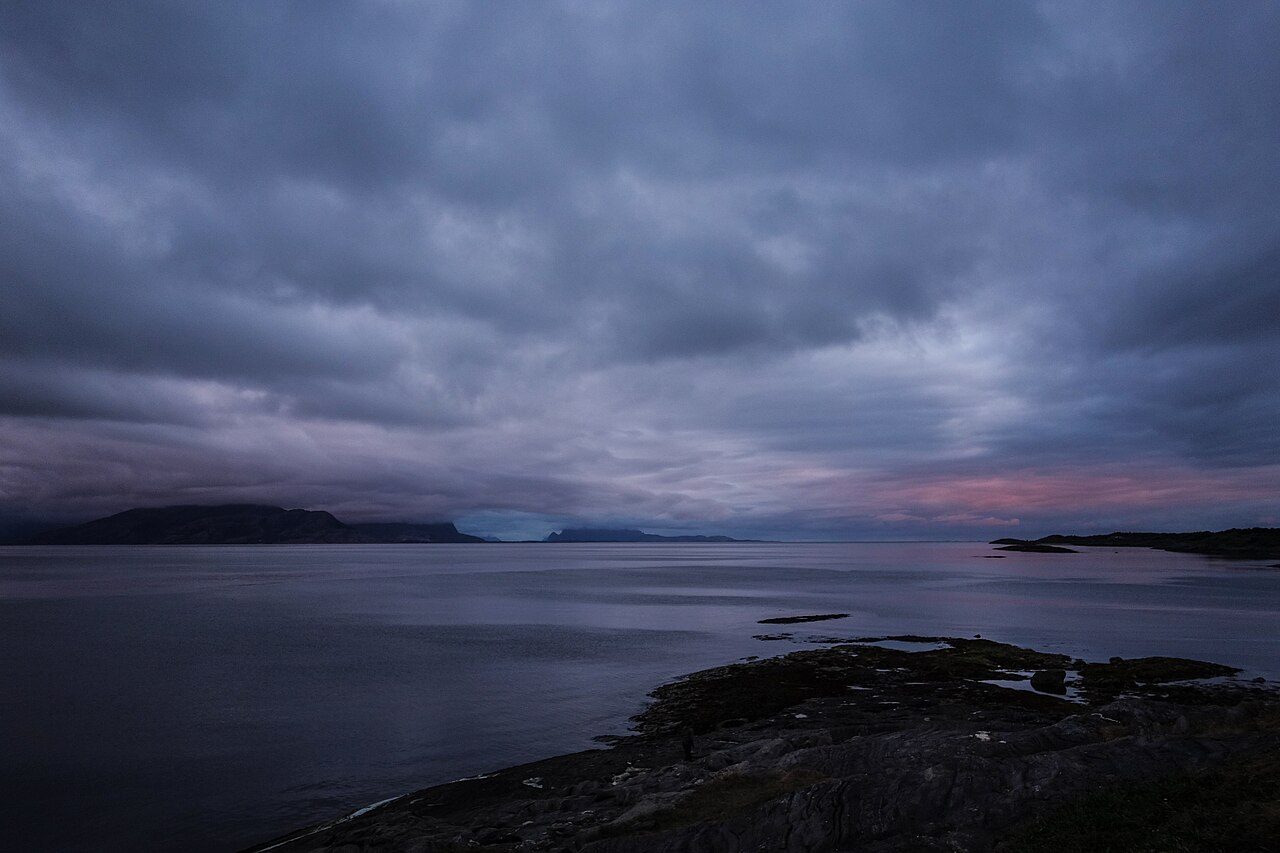 Sørvendt sandstrand i Ausvika med grunt vann og Landegodefjorden i bakgrunnen, Bodø kommune