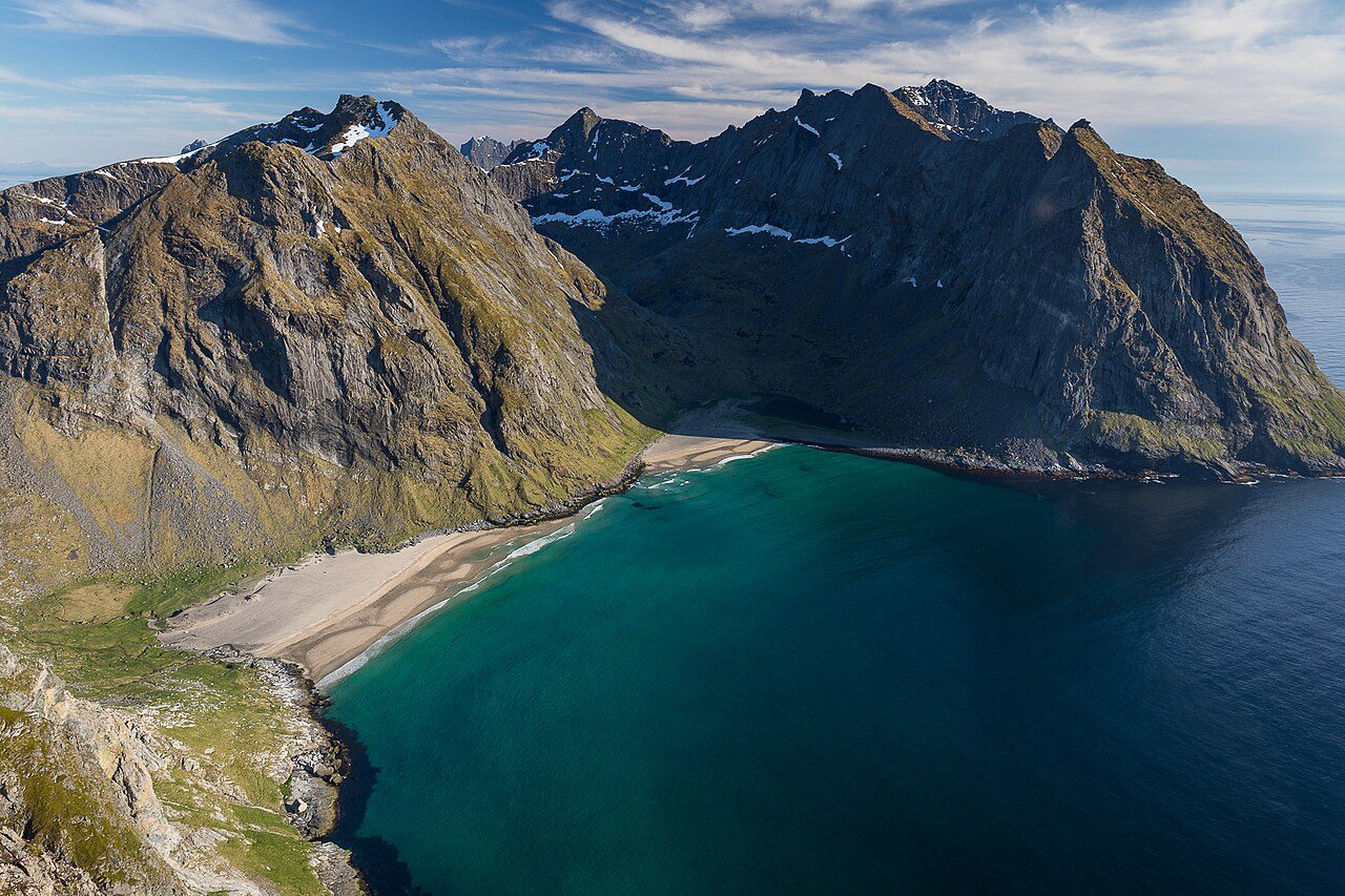 Kvalvika strand sett fra Ryten med hvit sand og turkist hav omkranset av fjell i Lofotodden nasjonalpark