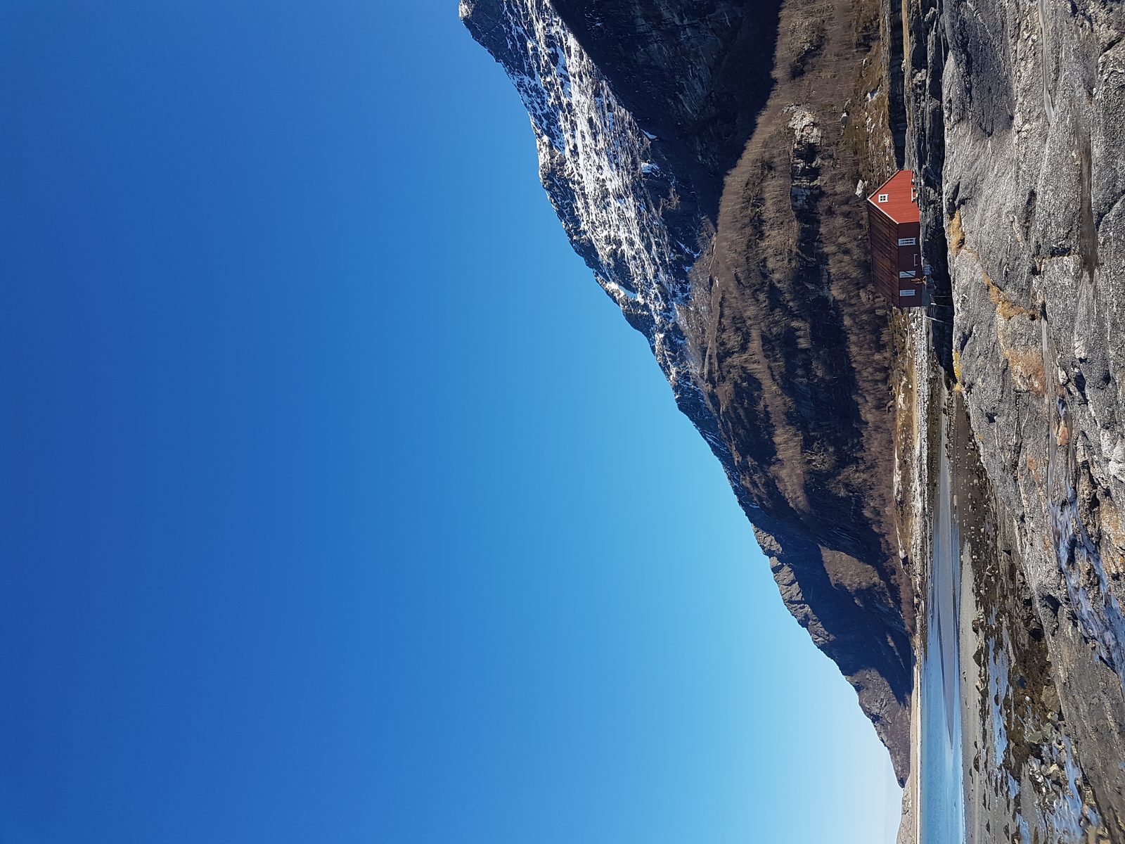 Mjelle strand ved Bodø med kystveien, bratte fjell og blå himmel