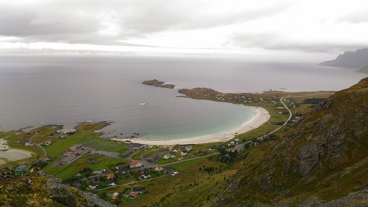 Rambergstranda med fin hvit sand og bratte lofotfjell i bakgrunnen, sett fra rasteplassen ved Jusnesvika