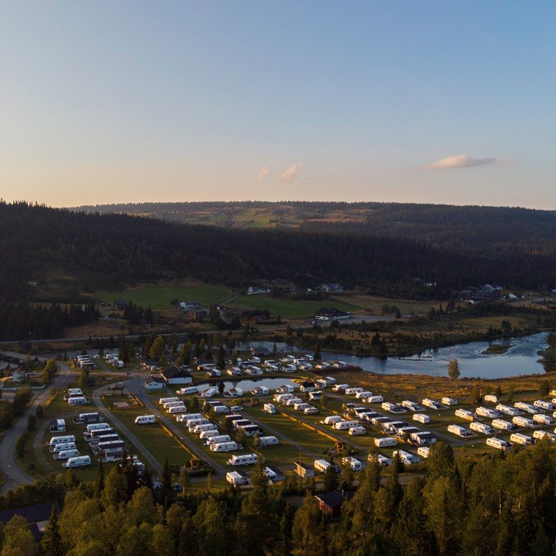 Bjørkestølen Helårscamping i Tisleidalen sett fra dronen med ørretelv og fjellandskap rundt
