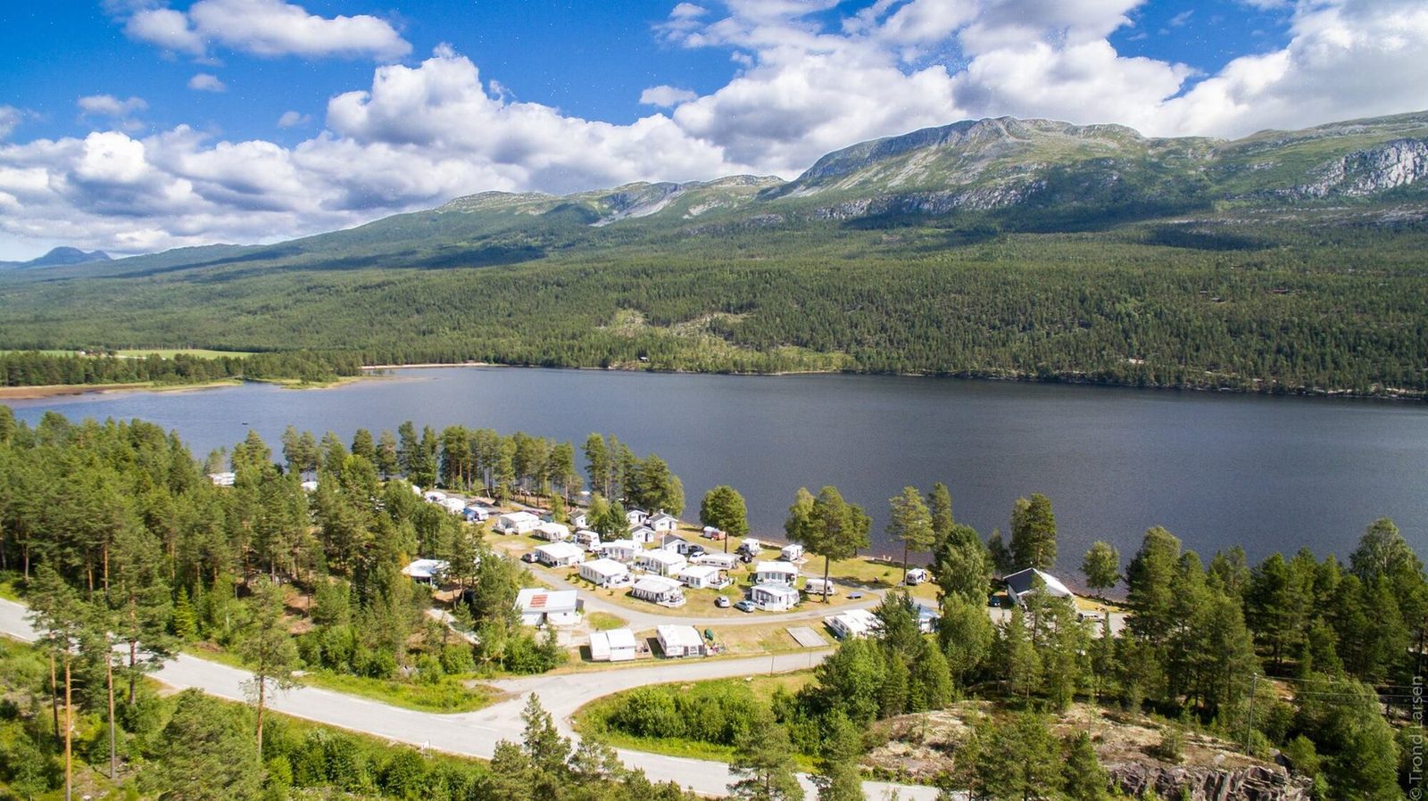 Blefjell Camping ved Sandvatn med utleiehytter og skogkledde åser i Hovin Telemark