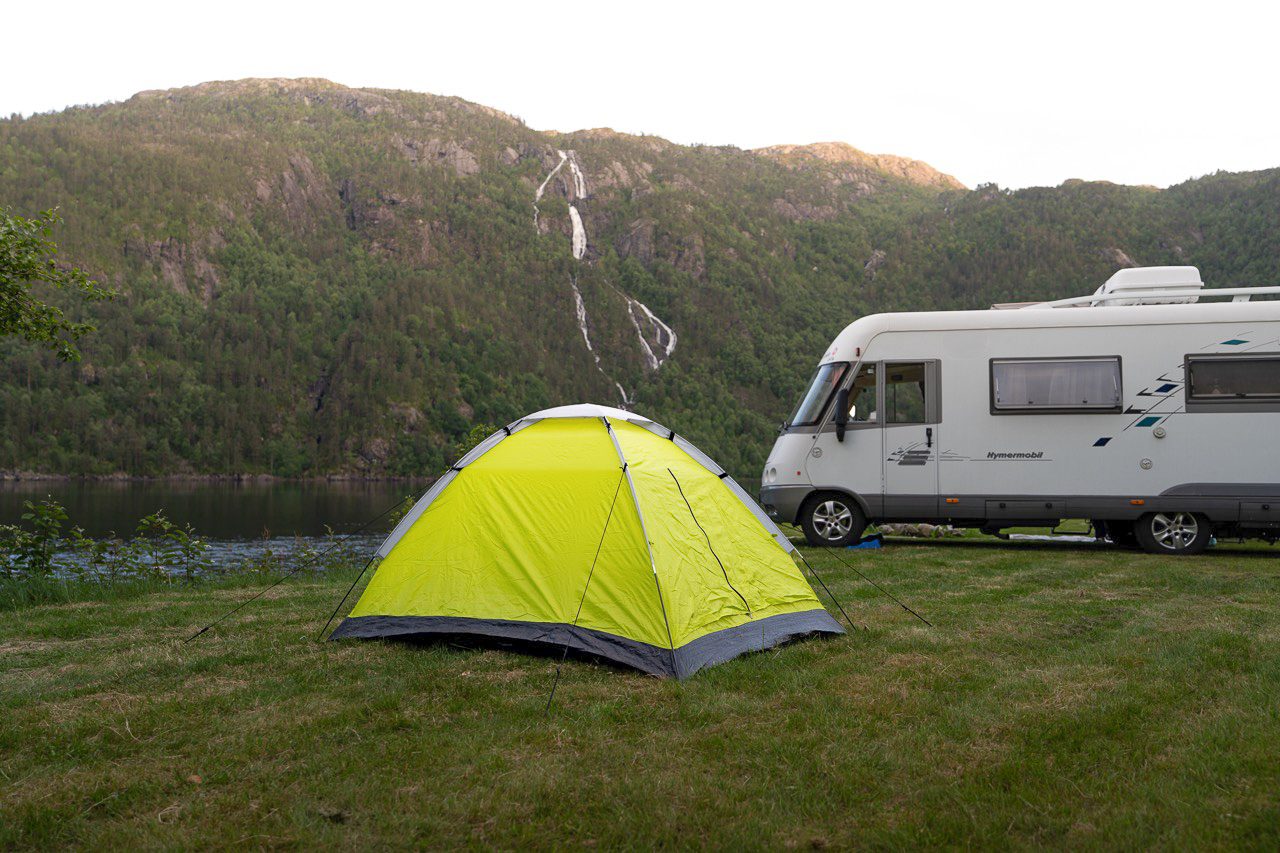 Camp Åkrafjorden ved fjordkanten med stupbratte fjell i bakgrunnen