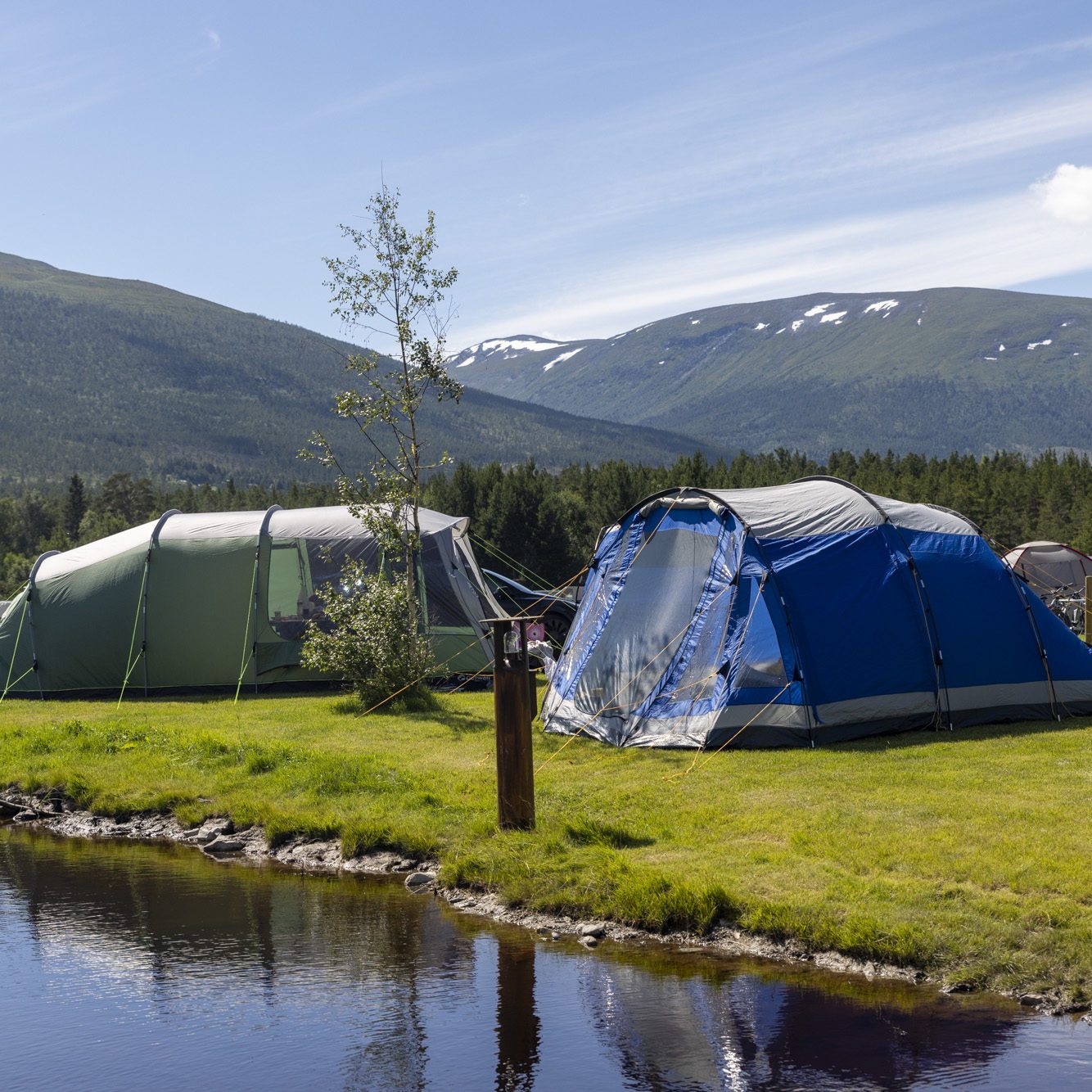 Dønfoss Camping i Skjåk med laftehytter og brevannsbasseng ved Dønfossen langs RV15