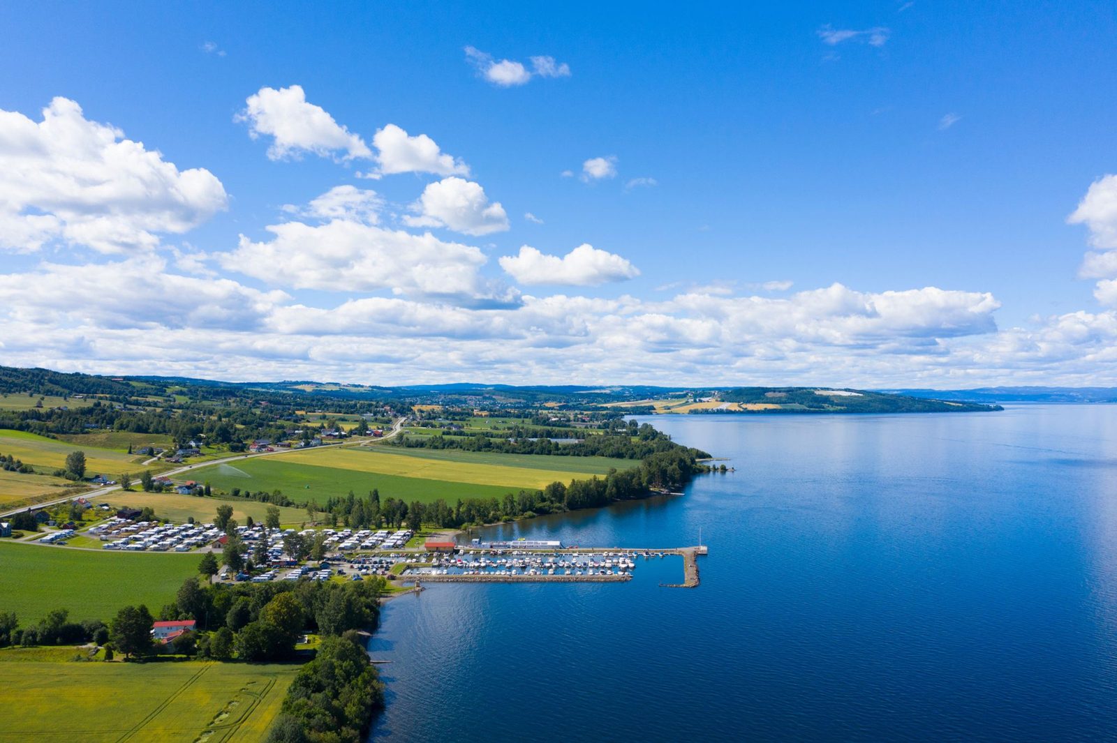 Bobil ved strandpark med utsikt over Mjøsa og brygge i Totenvika