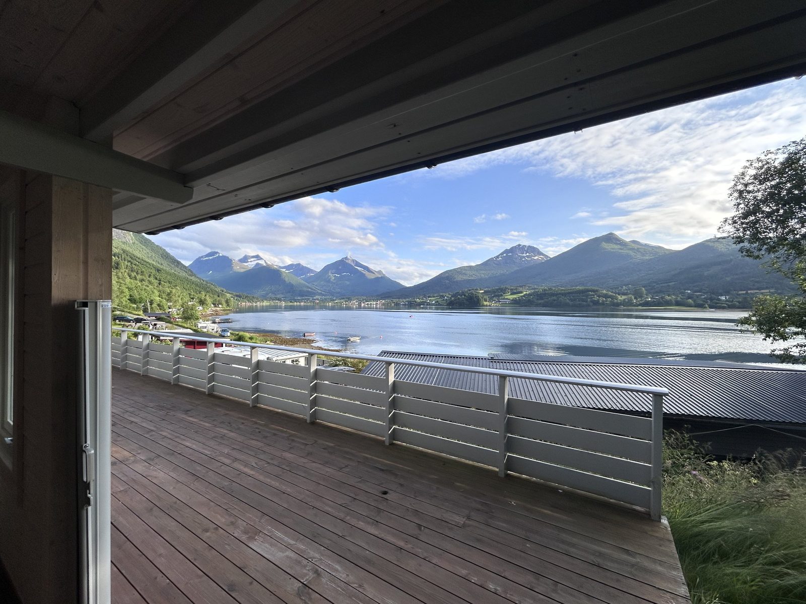Hytter ved vannkanten på Fagervik Camping med utsikt over indre Tresfjorden og fjellene rundt