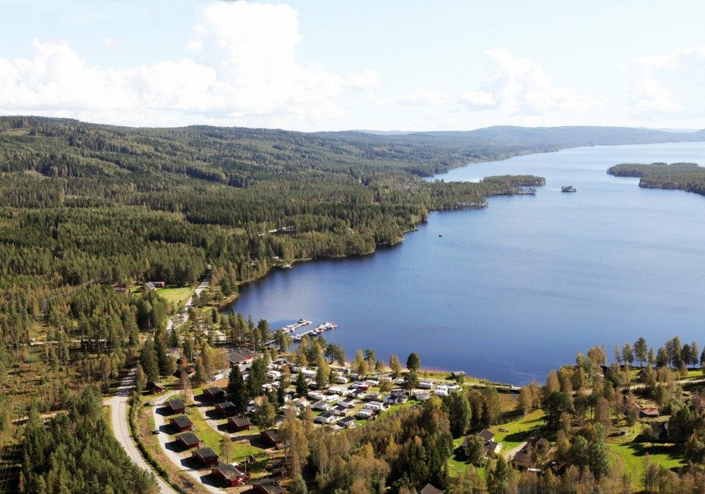 Finnskogen Turistsenter ved bredden av innsjøen Skasen i Grue, med hytter og marina omgitt av tett barskog