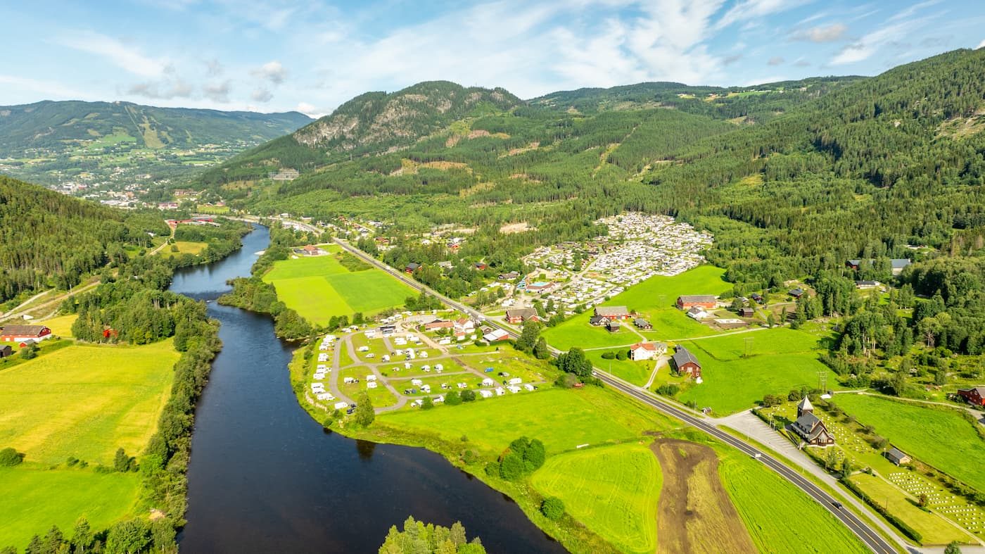 Bobiler og campingvogner på First Camp Gol – Hallingdal med Hallingstampen Friluftsbad i forgrunnen