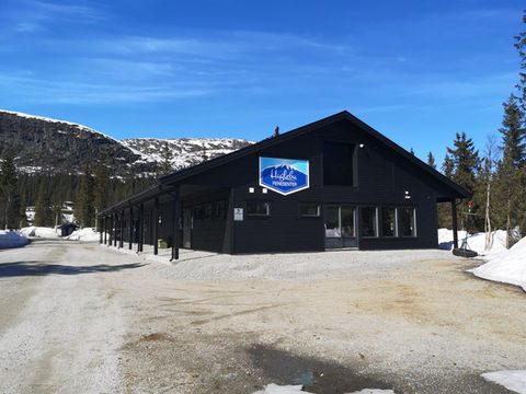 Bobiler og campingvogner på Haglebu Feriesenter med Haglebunatten i bakgrunnen