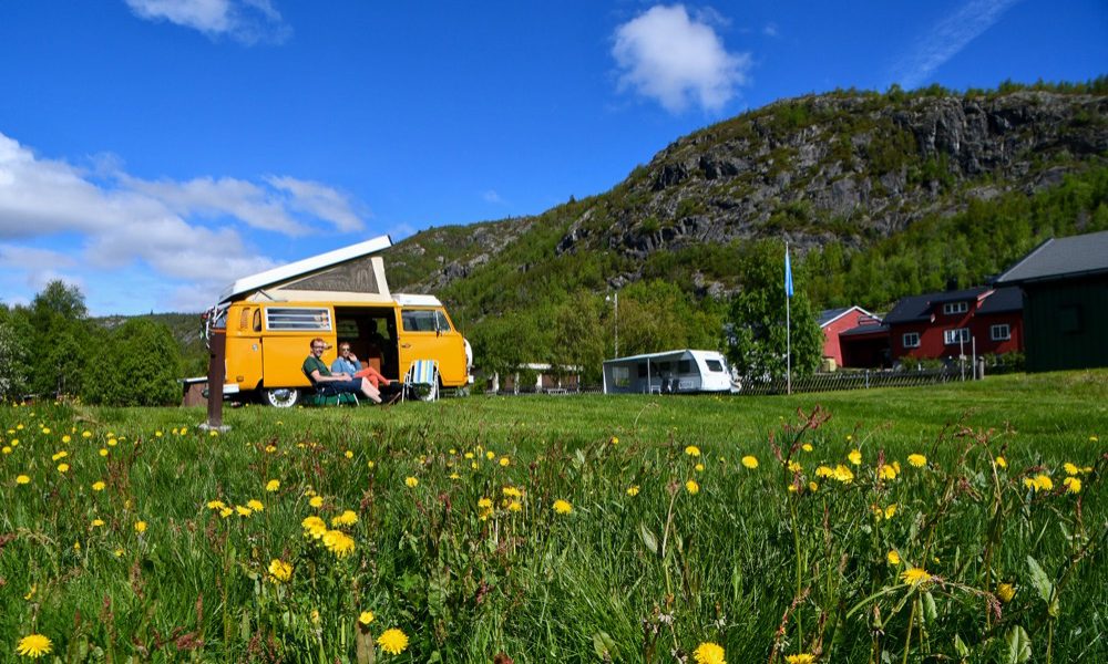 Hemsedal Fjellcamp på gården Hulbak Søre med campingvogner og fjellutsikt over Hemsedal på solsiden av dalen.