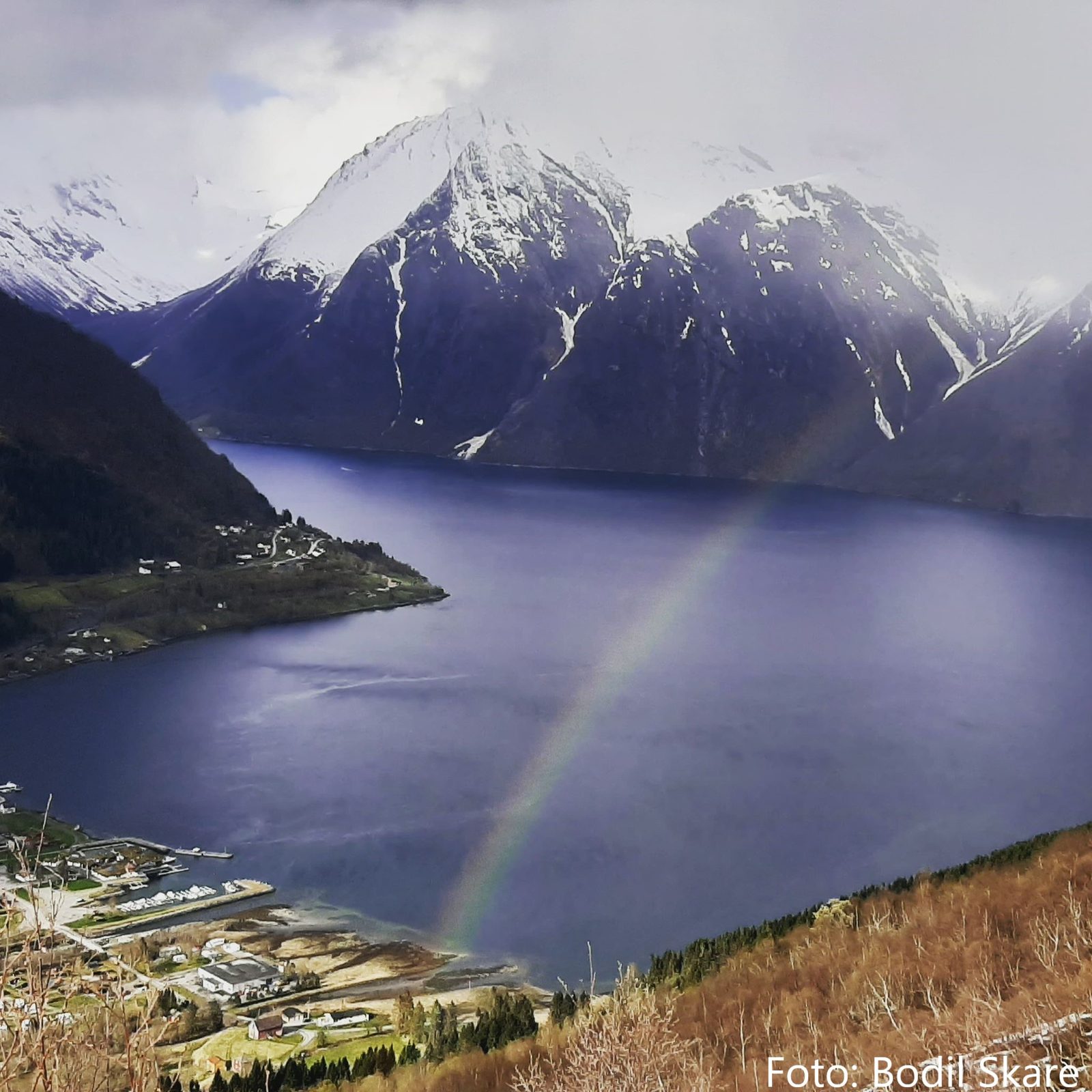 Hjørundfjord Camping ved fjorden med Sunnmørsalpenes tinder i bakgrunnen