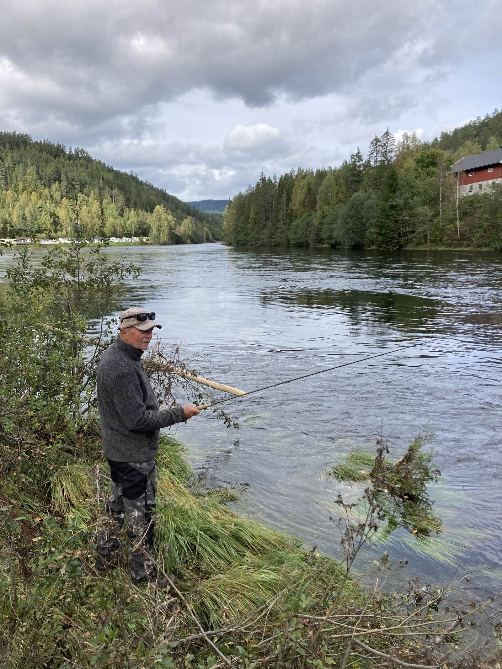 Hytter og campingvogner på elvebredden ved Numedalslågen på Holman Camping i Rollag