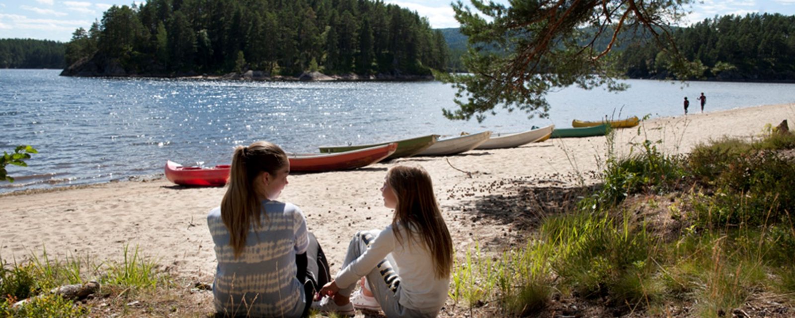 Bobiler og campingvogner langs sandstranden på Hornnes Camping der elva Otra møter Breiflå i Indre Agder.