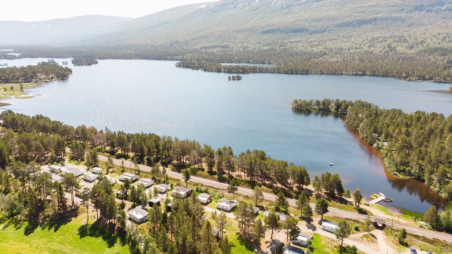 Lesjaskogsvatnet Camping i furuskog ved vannet langs E136 i Lesja, med fjellene i bakgrunnen