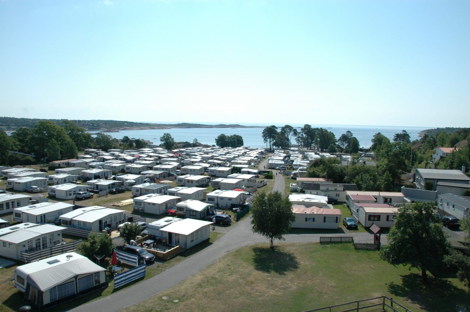 Oversiktsbilde av Lydhusstranda Camping ved sjøen sommerstid