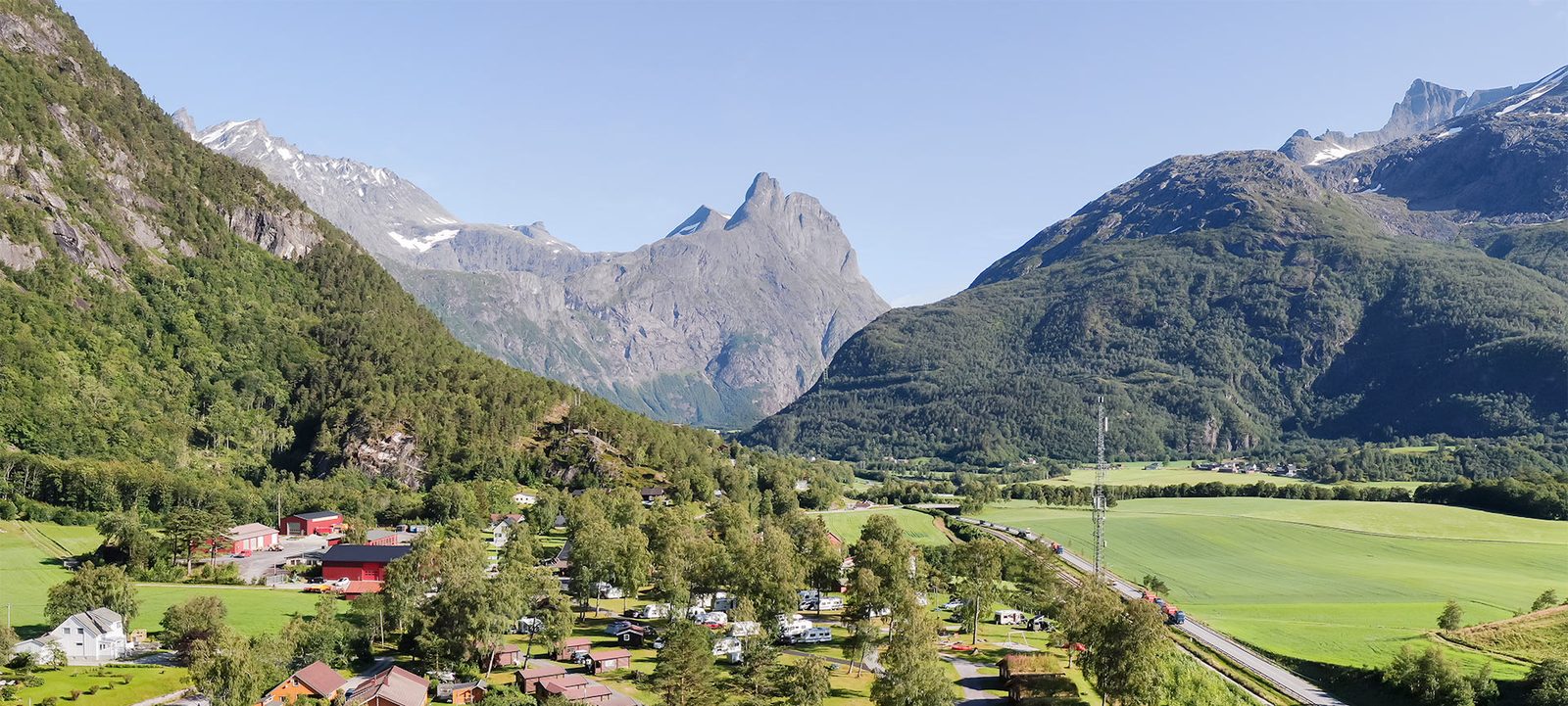 Hytter og bobilplasser ved Mjelva Camping med Romsdalshorn og Trolltindene i bakgrunnen