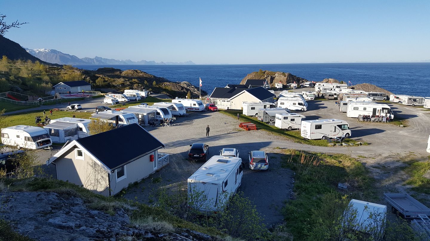 Bobilplasser på Moskenes Camping med Lofotveggens fjellrekke og Vestfjorden i bakgrunnen