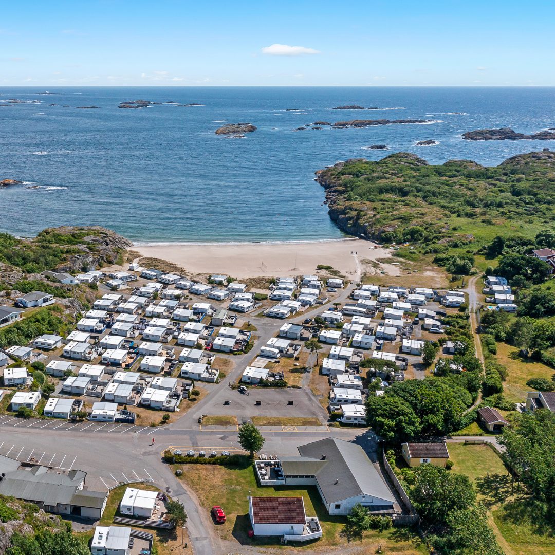 Bobiler og campingvogner på Oddane Sand Camping ved sandstranden i Nevlunghavn