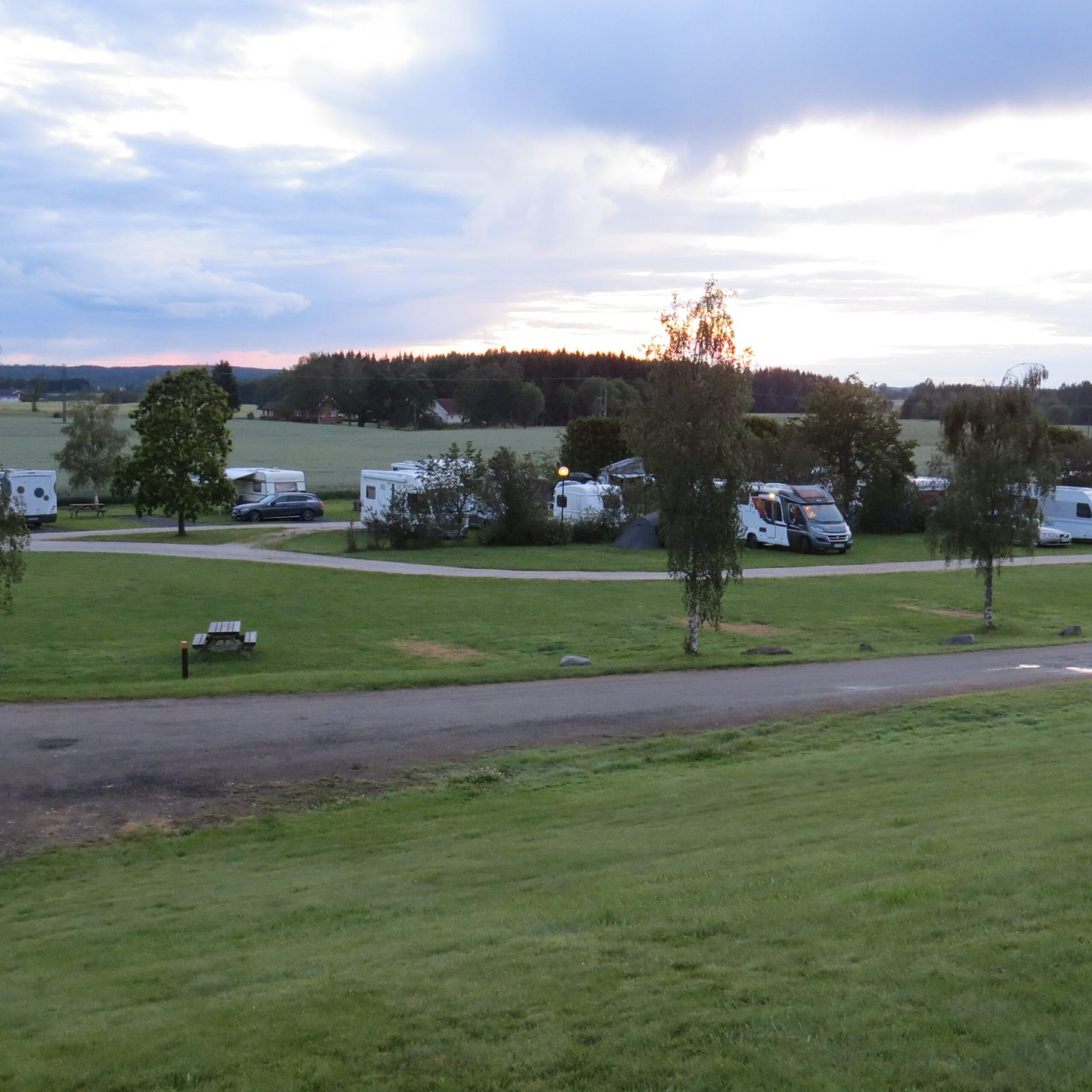Olberg Camping i Trøgstad med hytter og bobilplasser omgitt av åker og skog i Indre Østfold
