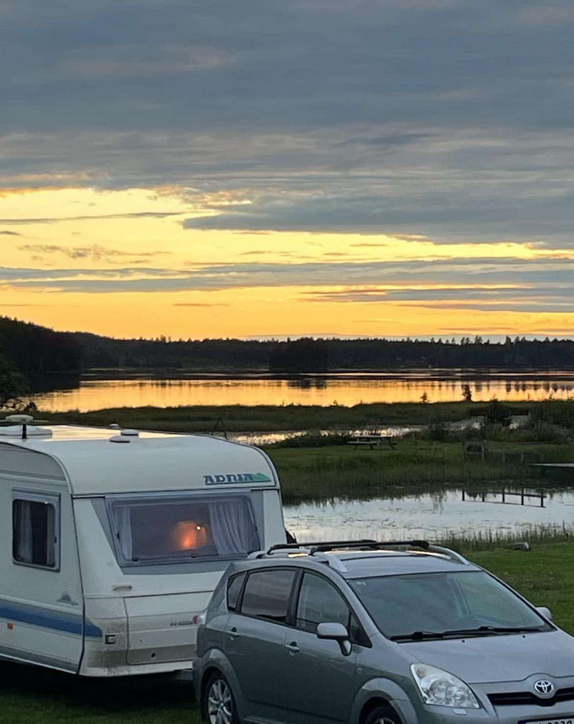 Bobil og campingvogn med utsikt over Rokosjøen i kveldssol