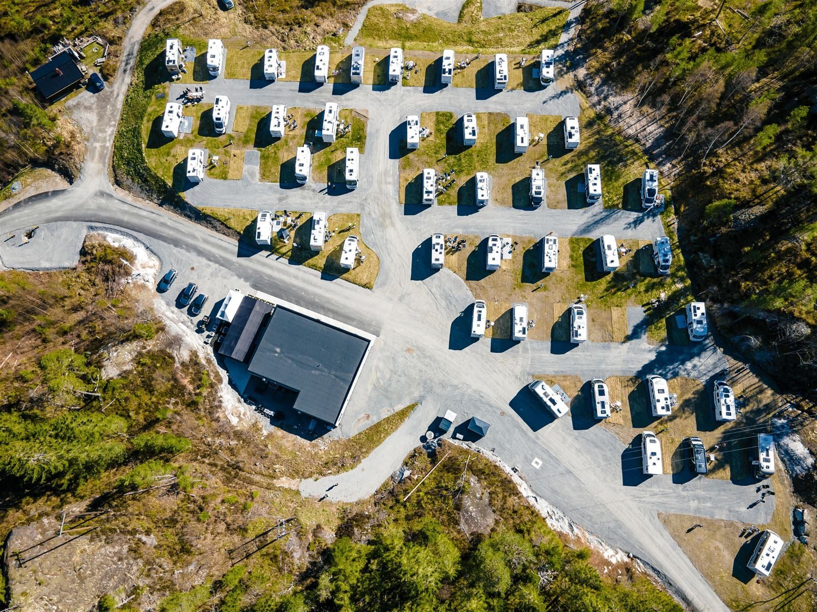Sandeåsen Feriesenter høyt over Lovatnet i Lodalen, med bobiler på panoramaplassene og fjellsidene i bakgrunnen