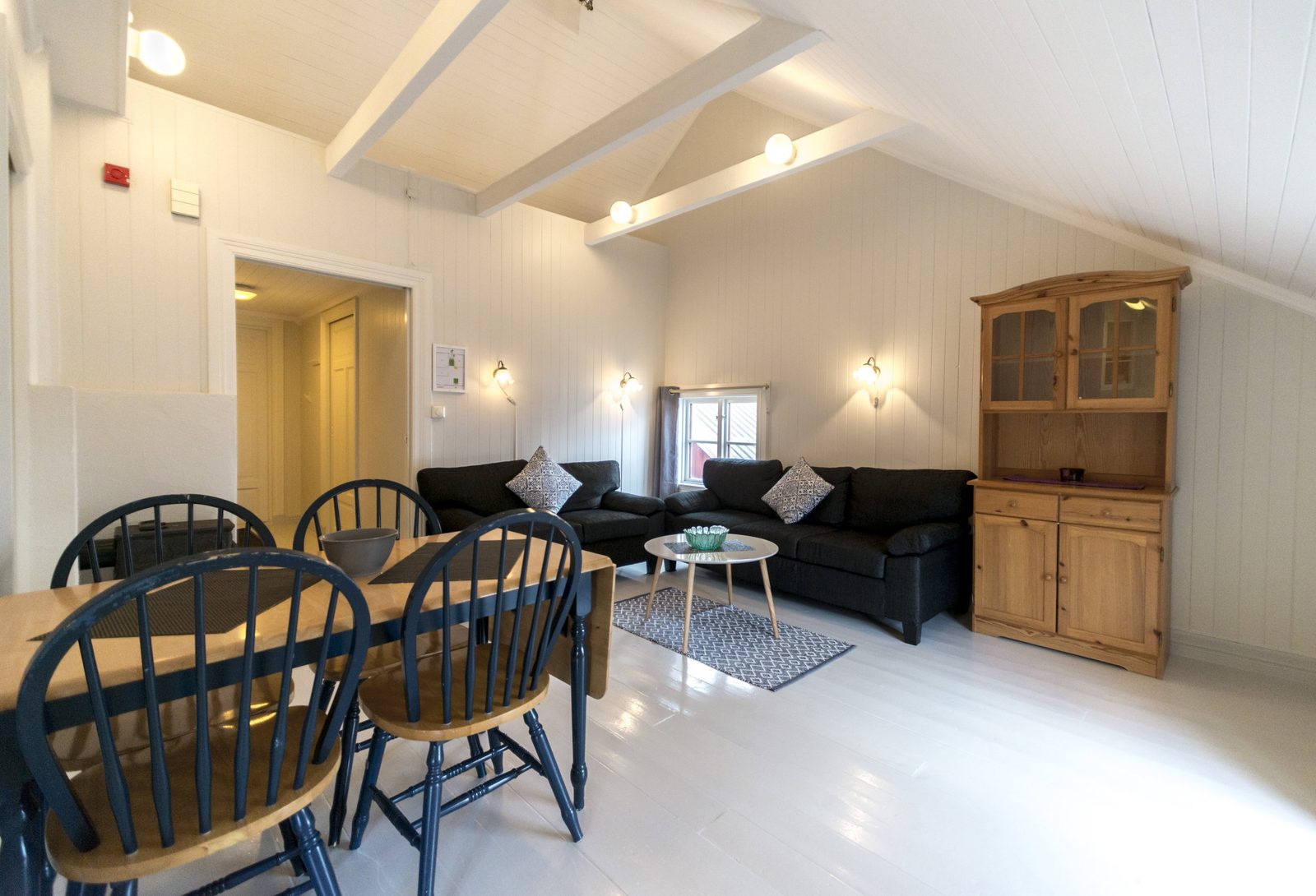 Sjøhus og campingvogner ved fjorden på Sandvika Fjord og Sjøhuscamping i Kabelvåg med Lofotfjellene i bakgrunnen