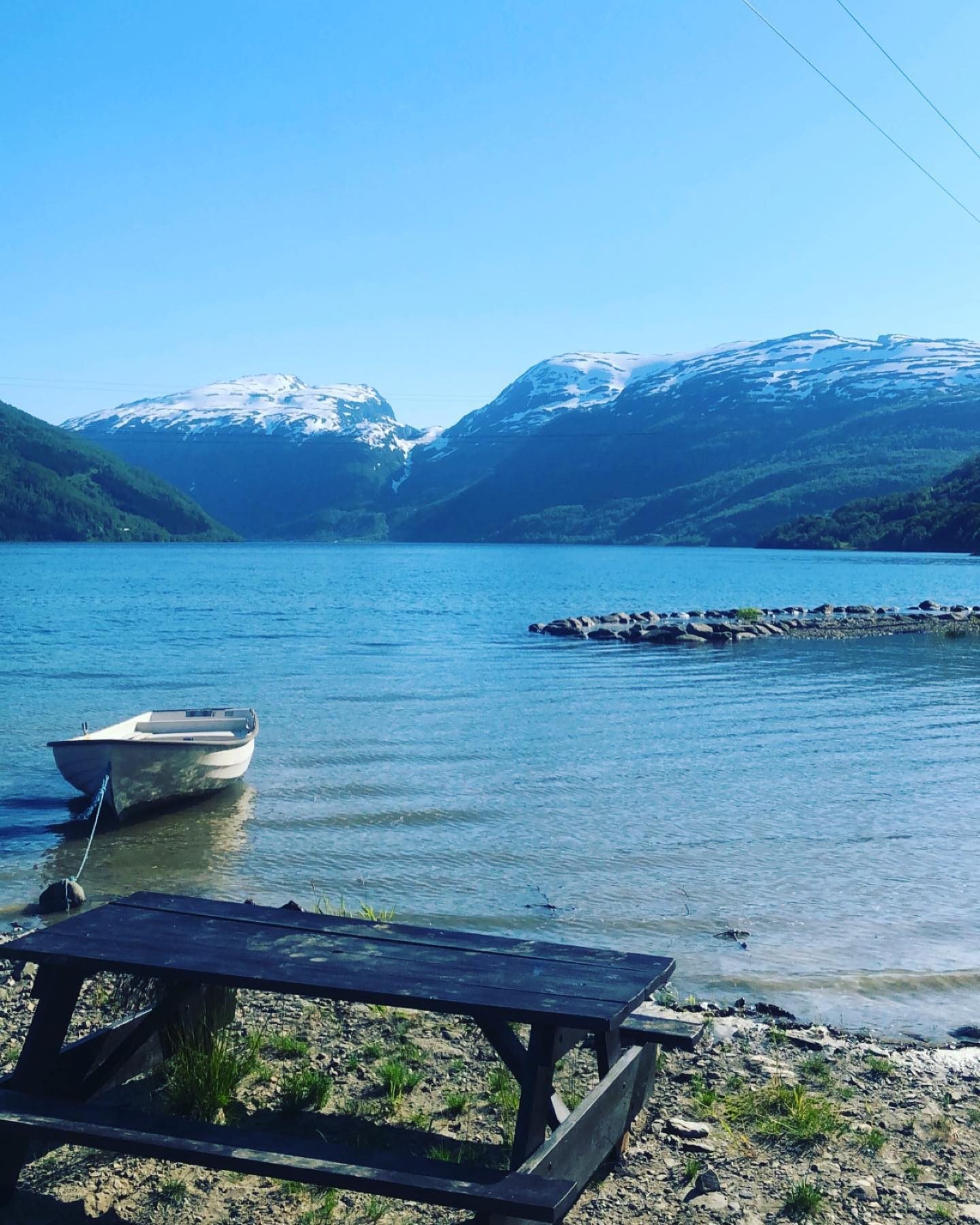 Seim Camping ved Røldalsvatnet med fjell og campingvogner på gårdsplassen i Røldal