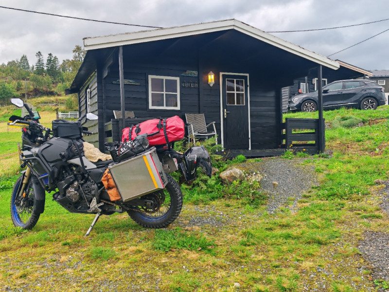 Hytter og rorbuer ved sjøkanten på Sjøbakken Gårdsferie i Leirfjord, med båtkai og utsikt over Leirfjorden på Helgelandskysten.