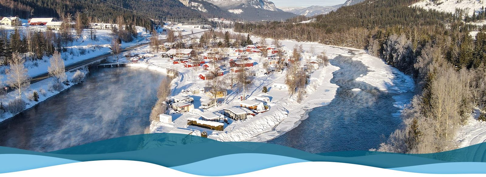 Sutøya Feriepark om vinteren med snødekte hytter ved Hallingdalselva i Nesbyen