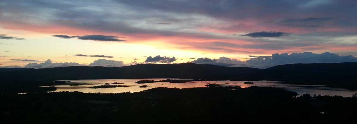 Trelavvo med glasstak i Hessdalen og nattehimmel med stjerner over fjellet