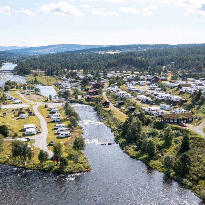 Vasetdansen Camping i Tisleidalen sett fra luften med elva Tisleia og fjellterreng 800 moh. i Vestre Slidre