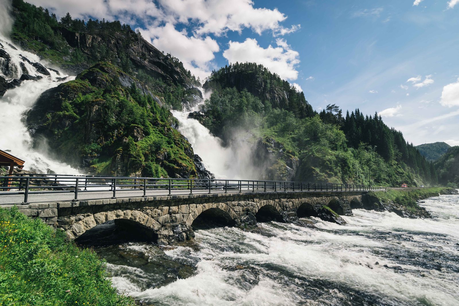 Låtefossen som dobbeltfoss der to elvegrener møtes over den seksbuede steinbroen langs RV13 i Hardanger