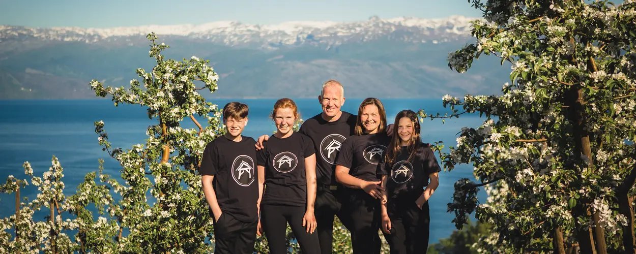 Spildegarden i Øystese med eplehage og fjord i bakgrunnen i Hardanger