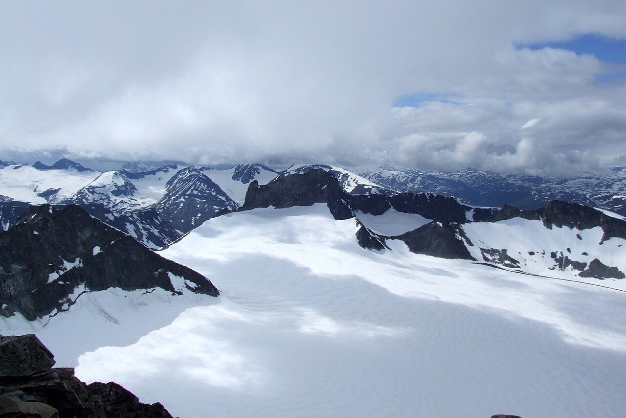 Galdhøpiggen og snødekte tinder i Jotunheimen nasjonalpark sett fra Sognefjellsvegen